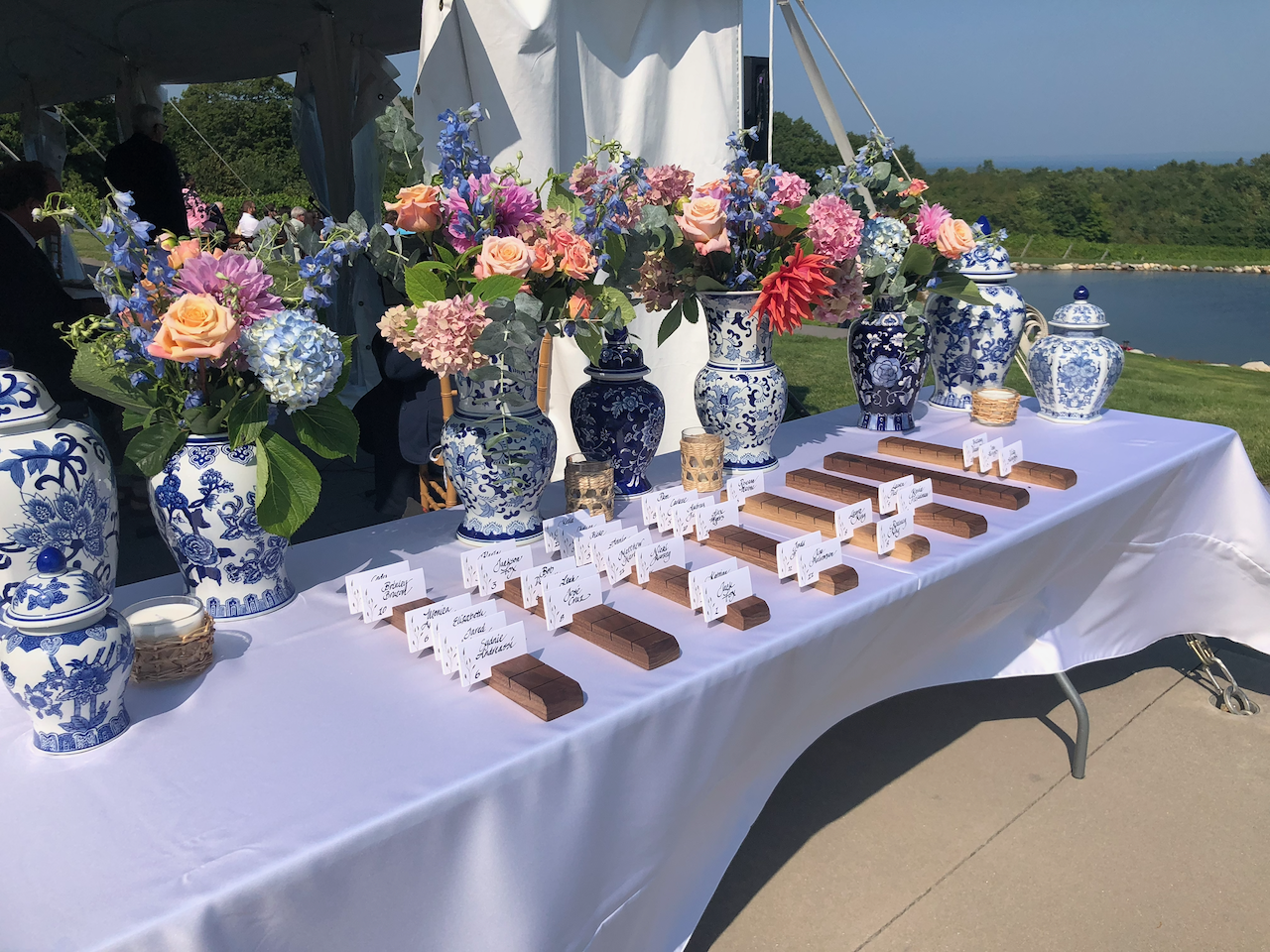 Wedding table with floral arrangements and blue and white porcelain vases.